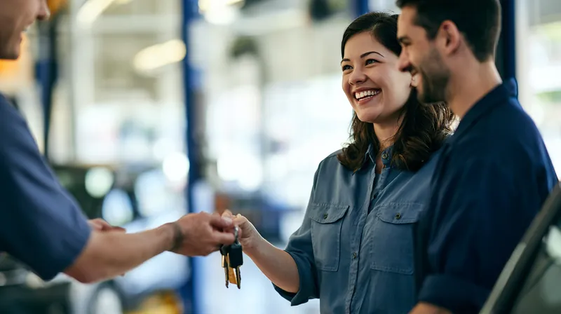 Mechanic handing car keys back to a woman in a bright auto service bay after a repair paid for with a $1,000 loan